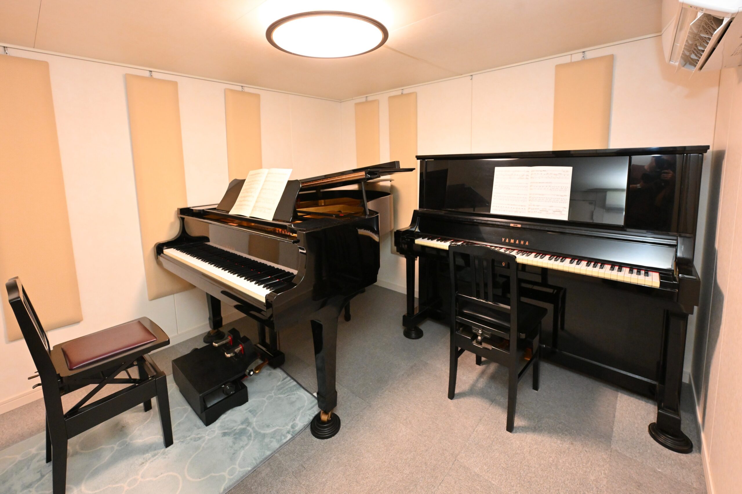 グランドピアノとアップライトピアノが設置されたレッスン室